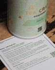 Green tea canister with a label on a wooden surface